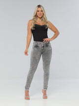 A woman in a black top and high-waisted grey skinny butt lift jeans, featuring a thick waistband and a flattering fit.