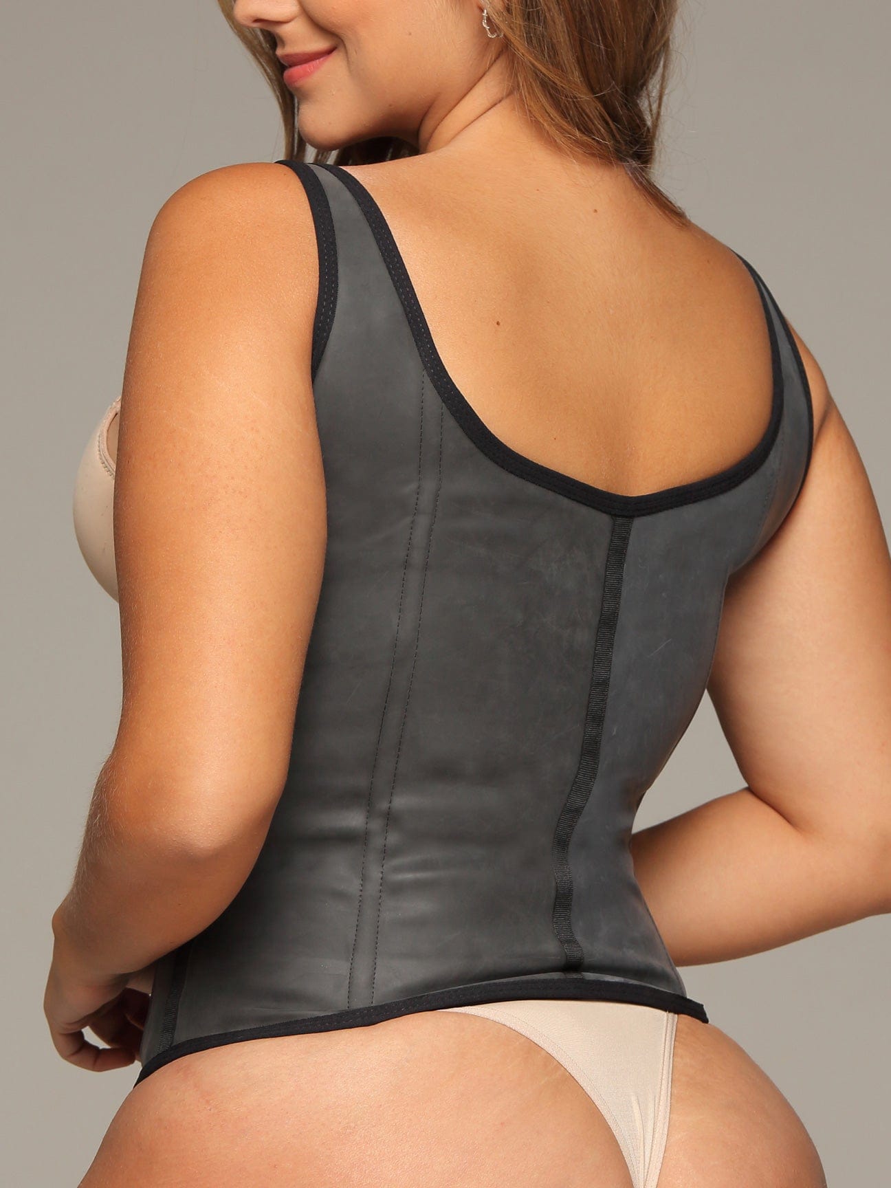 Back view of a model wearing the black semi vest latex waist trainer.